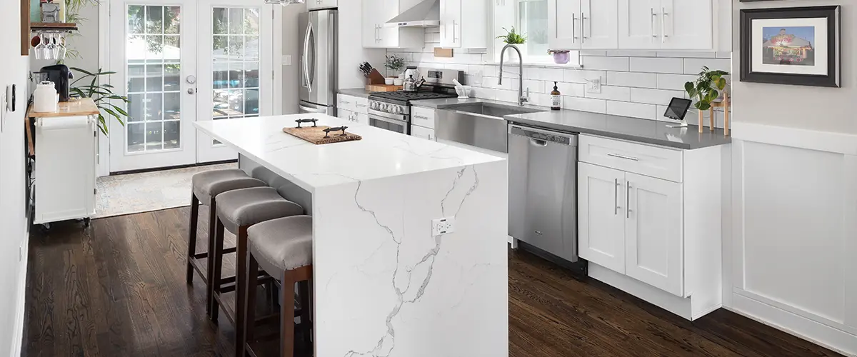 Marble waterfall countertops in a kitchen with wood floors
