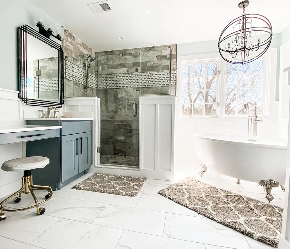 A remodeled bathroom with a simple vanity, a freestanding tub, and a walk-in shower