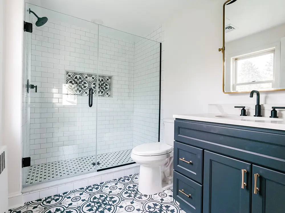 A new bathroom with a beautiful tile design and blue vanity