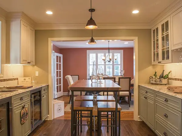 A kitchen with traditional cabinets and a tall kitchen island made of wood