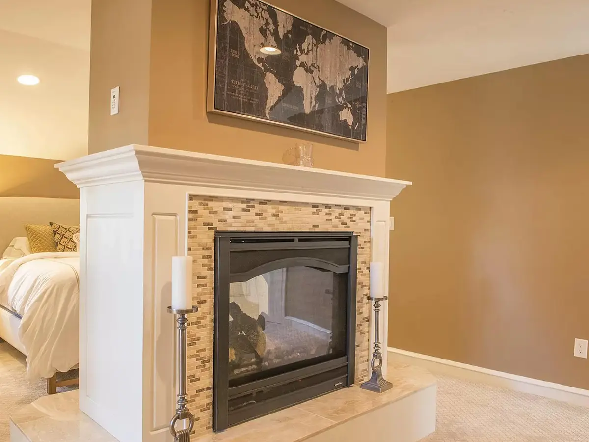 A fireplace with crown molding and a painting with the world map above it