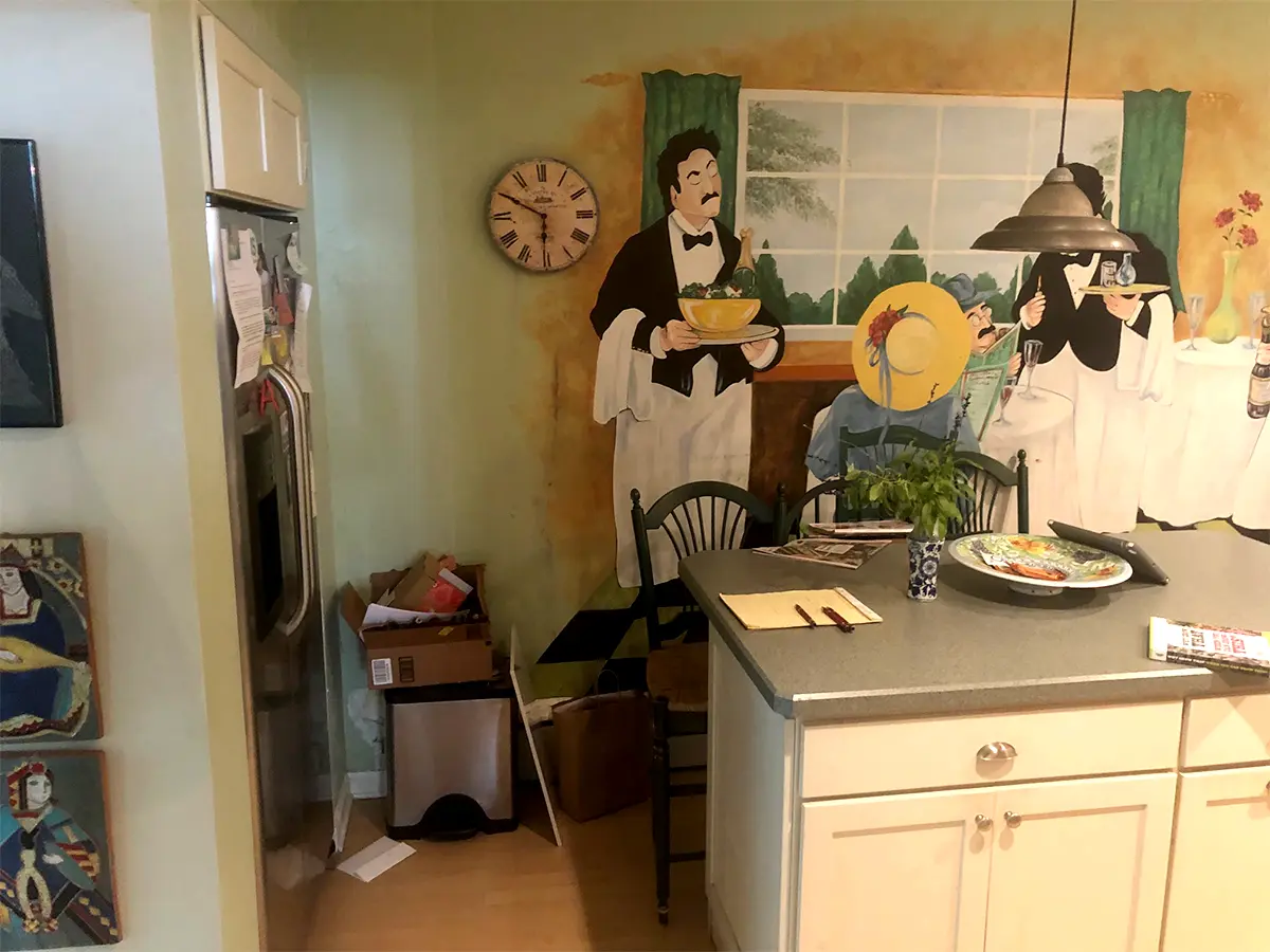 An old kitchen with a painting on the wall