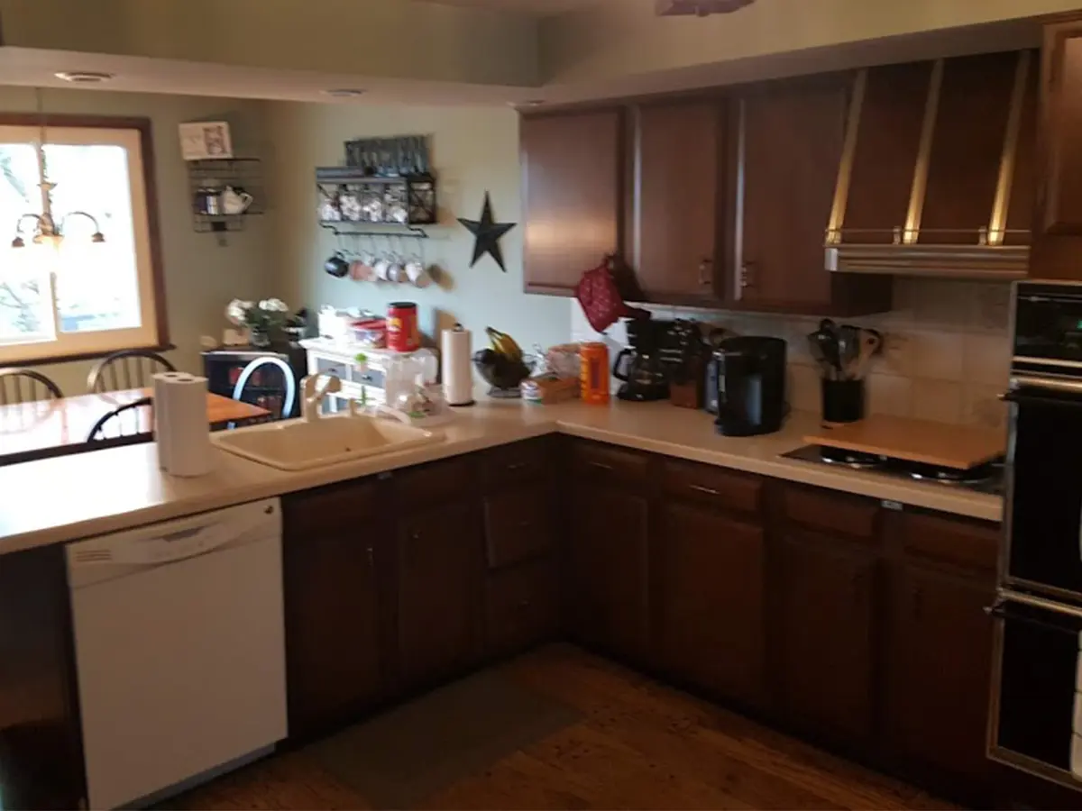 A dated kitchen with old wooden cabinets and laminate countertop
