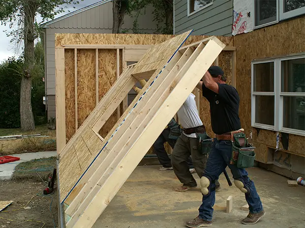 Builders raising a home addition bump-out