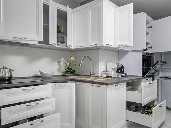 White kitchen cabinets with open doors and drawers