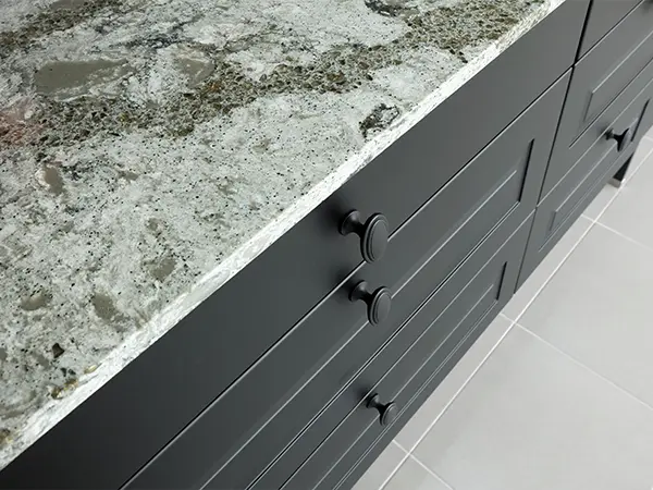 Black kitchen cabinets and drawers with granite countertop
