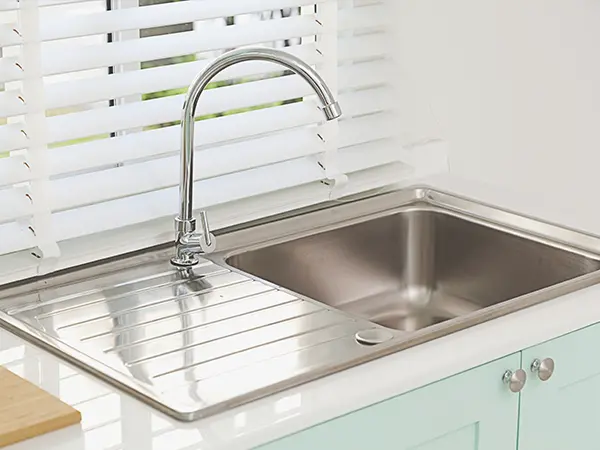 A drop-in sink with light blue cabinets