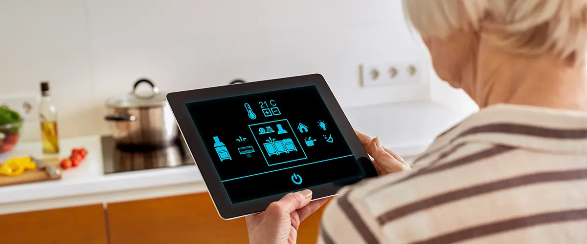 A homeowner working with a tablet connected to her kitchen appliances