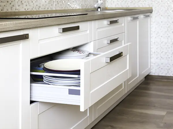 White cabinets with open drawers and black pulls