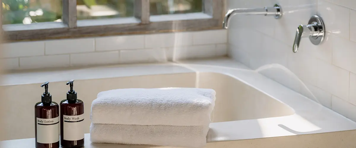 Cozy bathtub with two soap containers and towels