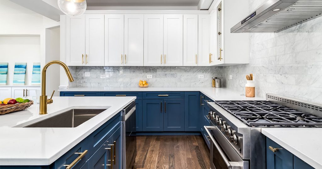 Beautiful navy blue base cabinets and white upper cabinets in a kitchen