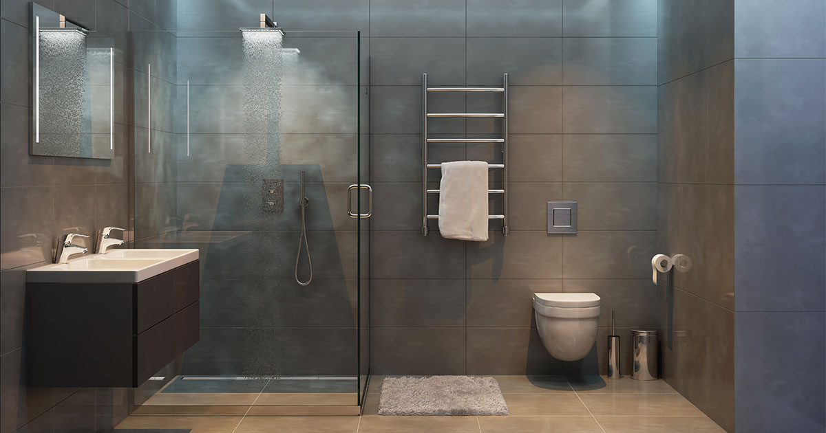 A glass shower in a bathroom with large gray tile walls