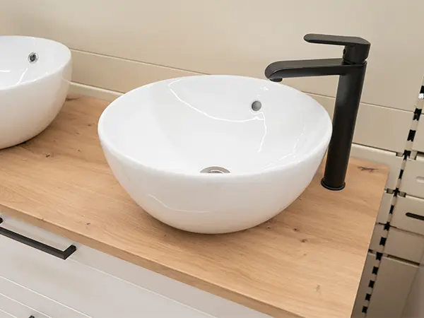 Wood countertops with white vessel sink and black faucet