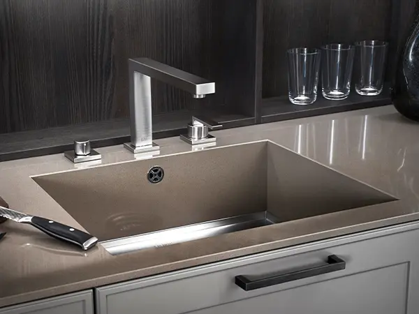 An undermount sink on a beige and modern countertop