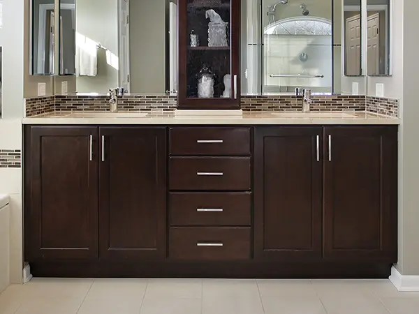 A dark wood vanity with two sinks