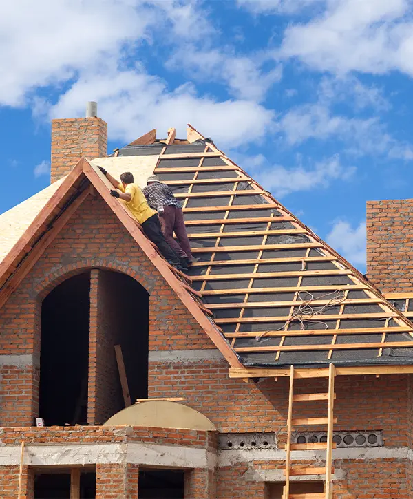 Contractors working on a brick home's roof