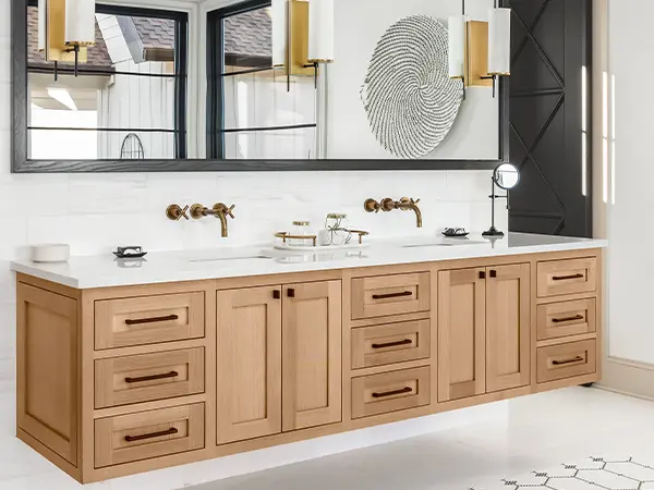 A double wood vanity with black pulls and large mirror