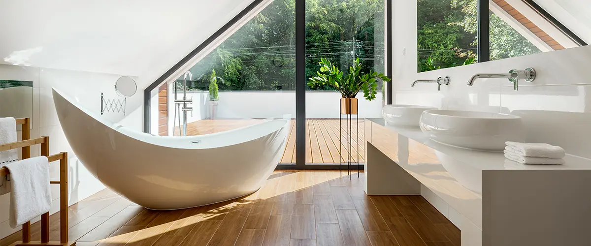 E fancy freestanding tub on a second-floor bathroom with wood flooring