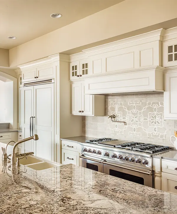 A kitchen with a granite countertop and white kitchen cabinets