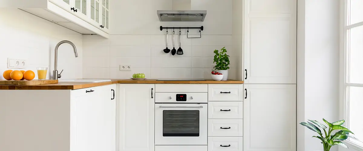 Traditional white cabinets with butcher block countertop and a small plant