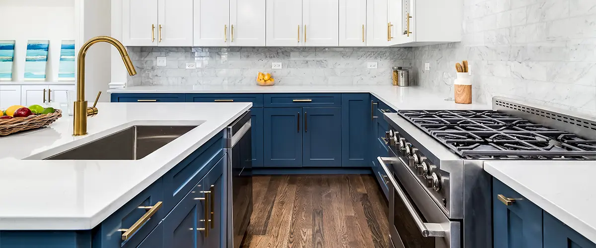 Navy blue base cabinets with white kitchen cabinets and golden hardware