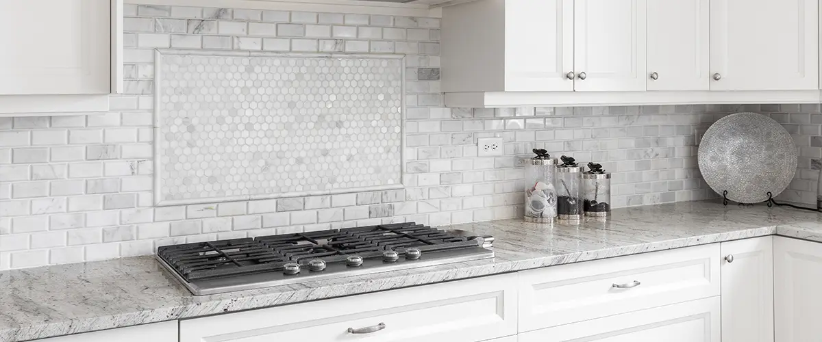 A tile backsplash in a white kitchen