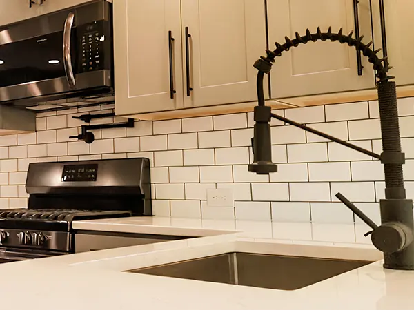 Black water fixture with beige kitchen cabinets