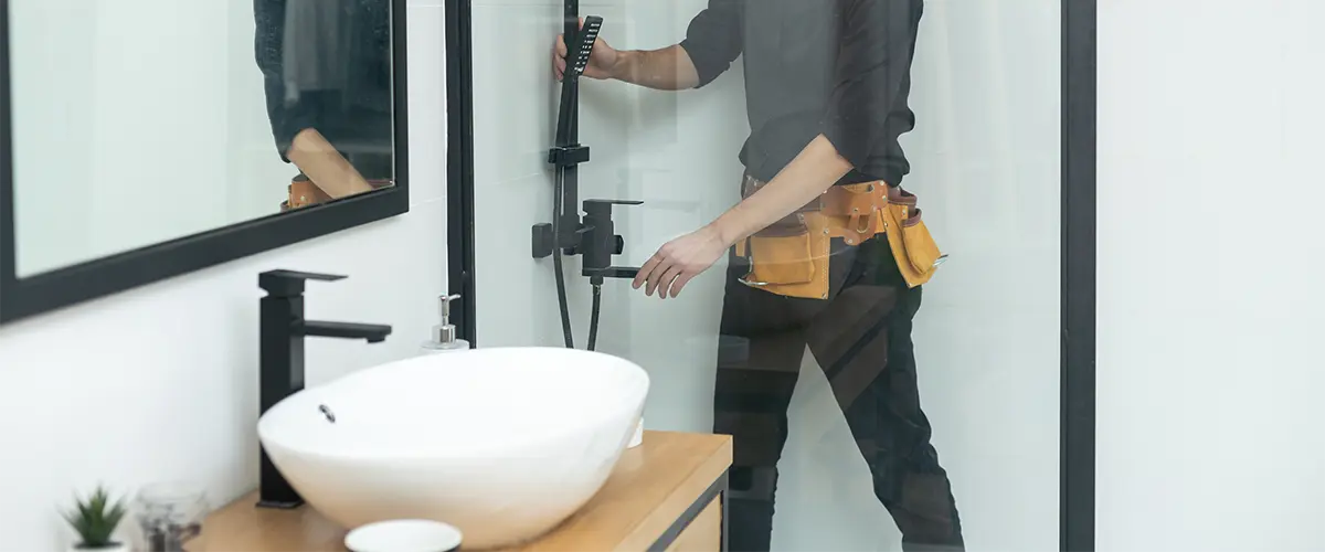 A professional bathroom remodeler installing a glass walk-in shower