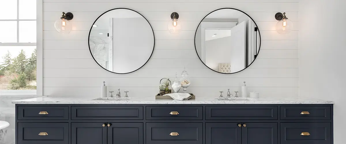 Navy blue double vanity with golden hardware with round mirrors