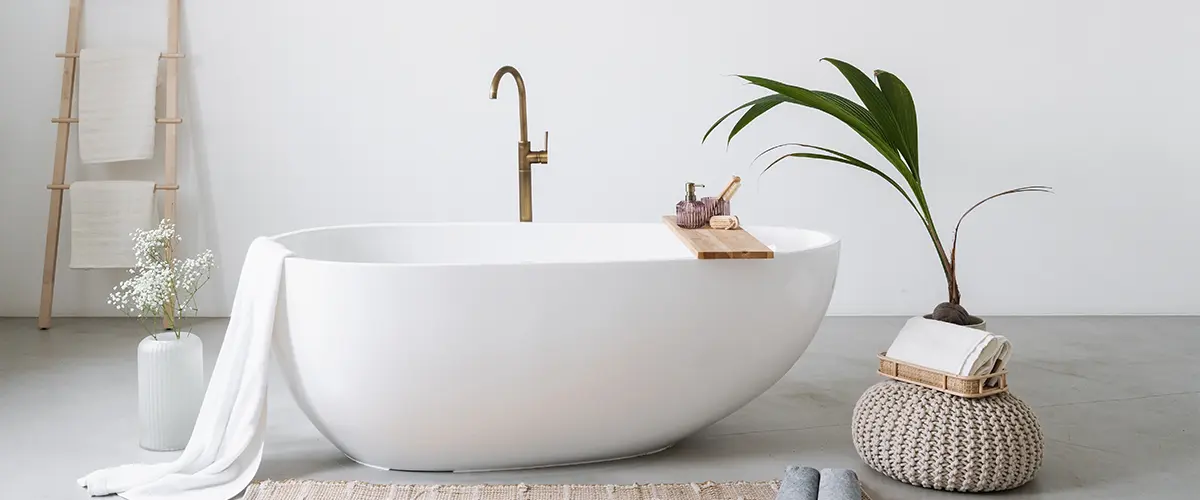 A freestanding tub with a plant and an epoxy flooring