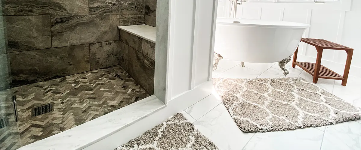 A bathroom floor and a shower tile surround