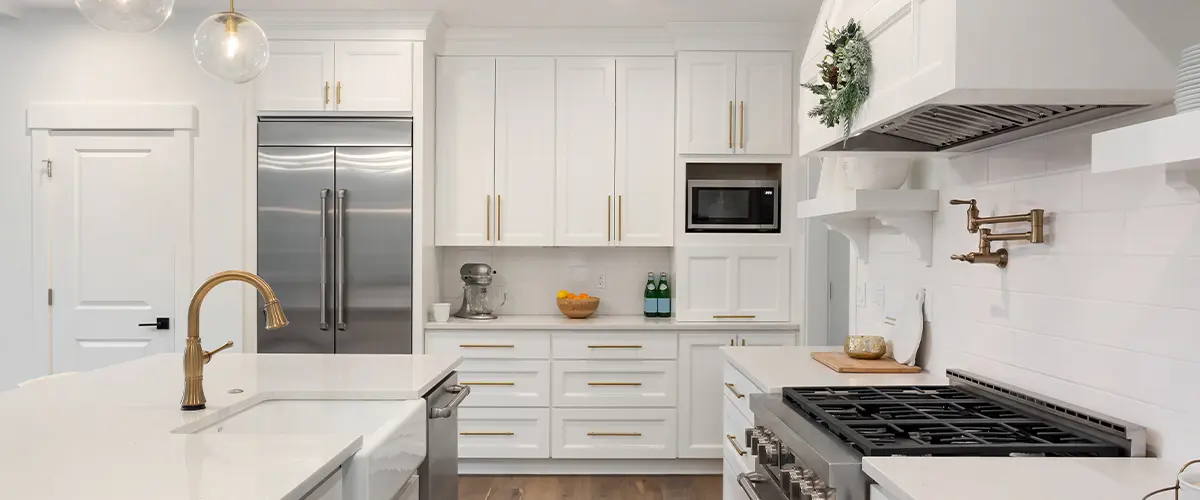 Styles of kitchen cabinets with golden hardware in an upscale kitchen space