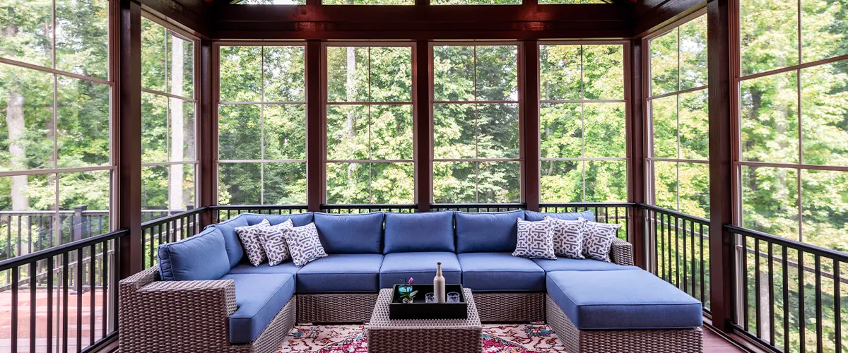New modern screened porch with patio furniture, summertime woods in the background