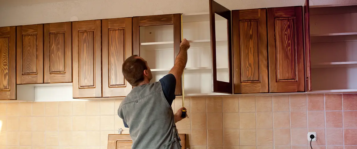 Carpenter working on kitchen cabinet removal and installation