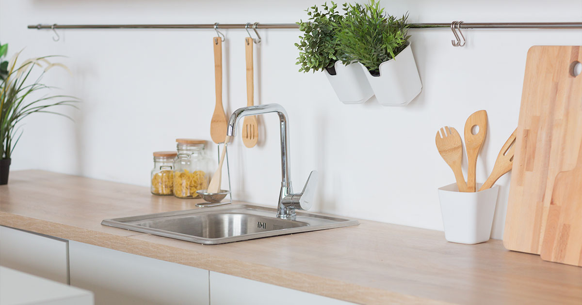 White kitchen Interior in scandinavian style with kitchenware and green plants