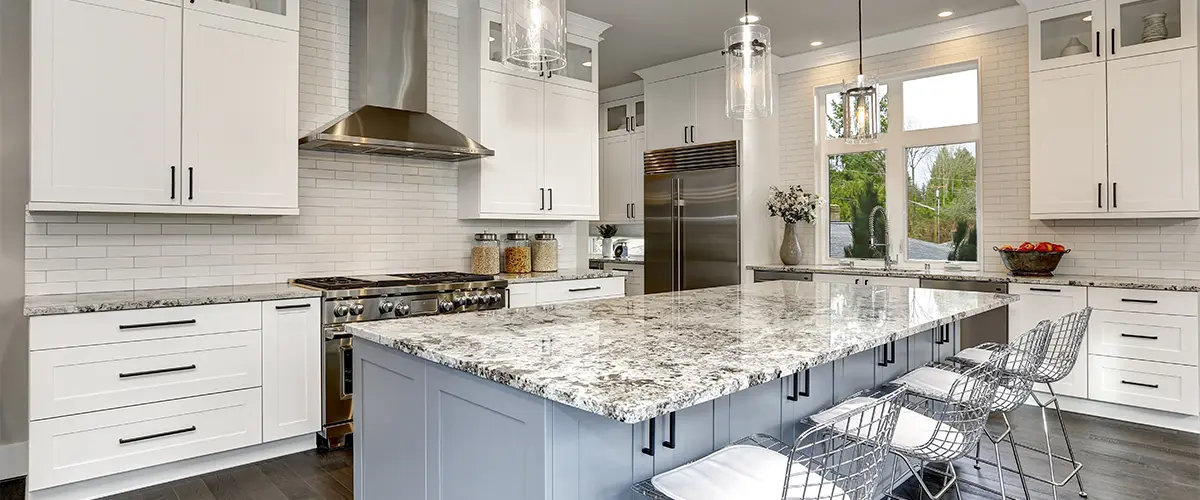 Modern kitchen remodeling in devon with white cabinets, granite countertops, stainless steel appliances, and large island, perfect for luxury home cooking and entertaining.