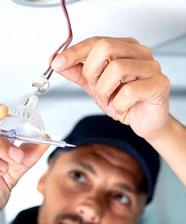 Electrician installing a ceiling light fixture in Springfield, Pennsylvania