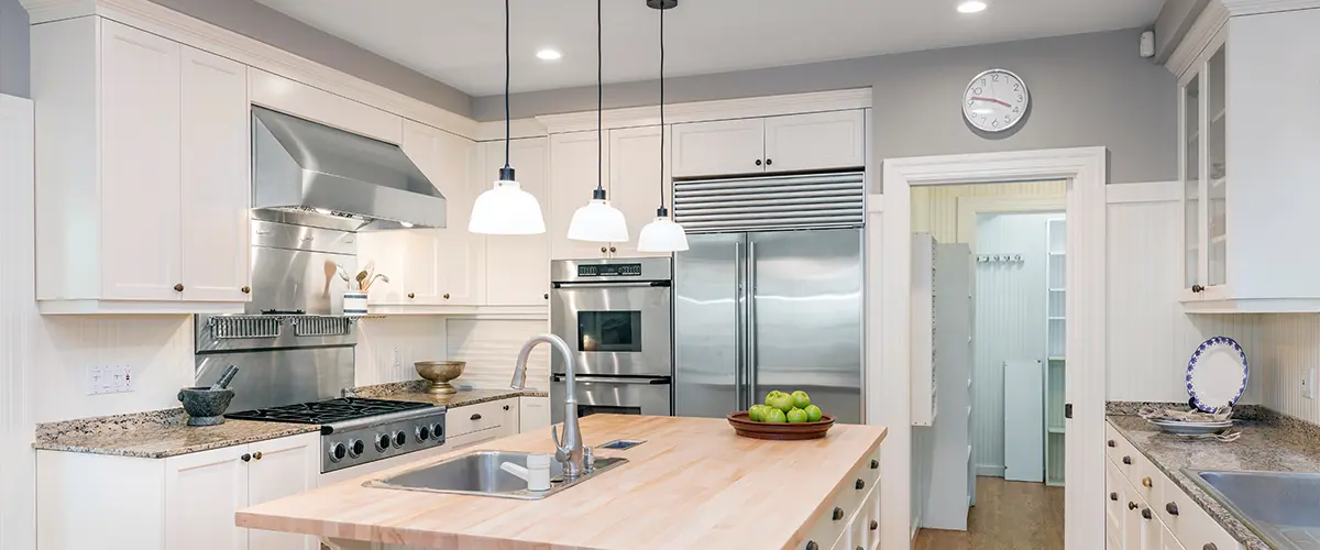 Amazing Luxury Kitchen Interior in white with wooden floor and kitchen island.