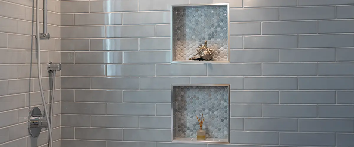 Bathroom shower with niche shelving and light gray subway tiles