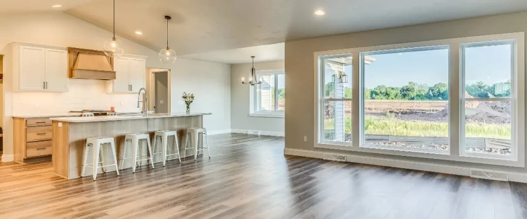 Spacious open-concept kitchen with large windows and wood flooring