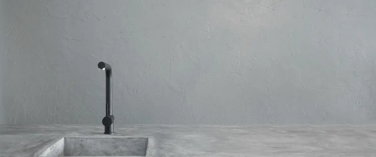 Minimalist concrete kitchen sink with textured wall backdrop