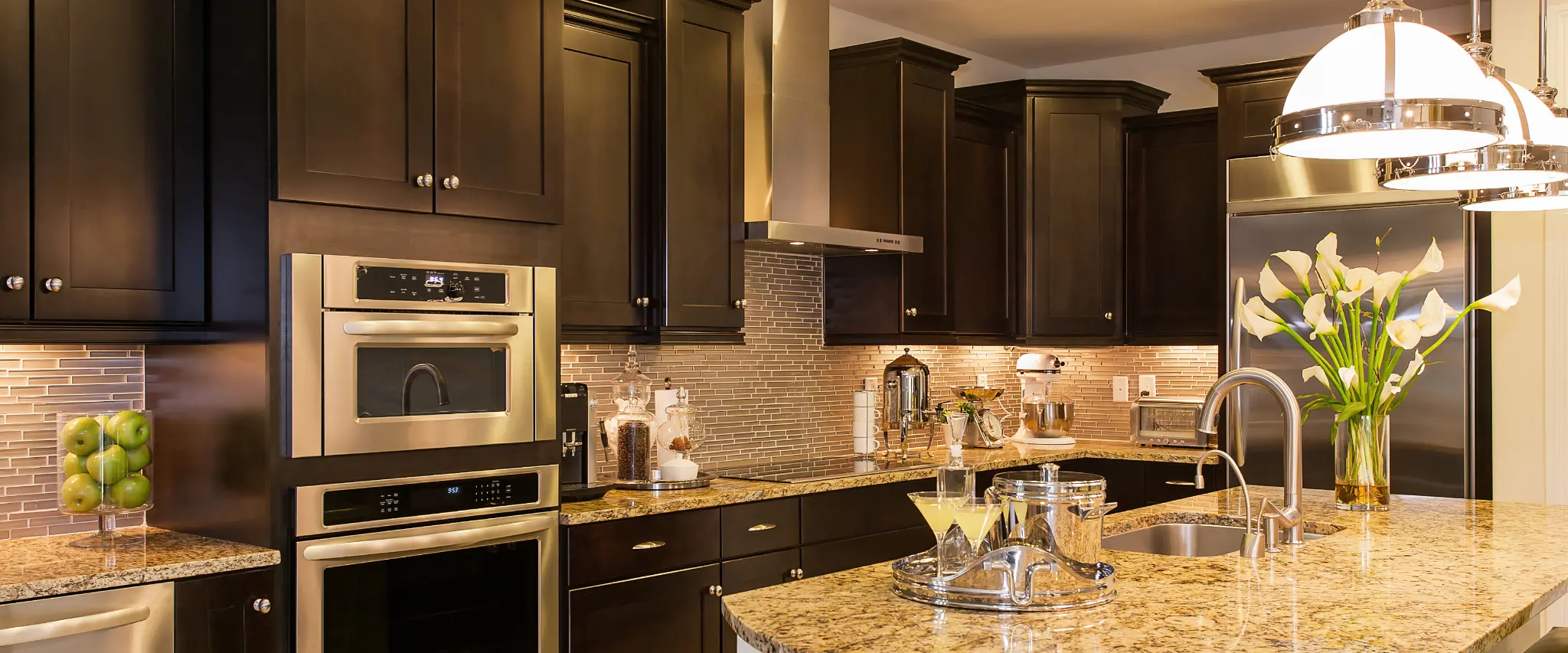 Luxury kitchen with dark wood cabinets and stainless steel appliances