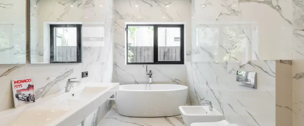 Bright bathroom with a freestanding bathtub and marble walls