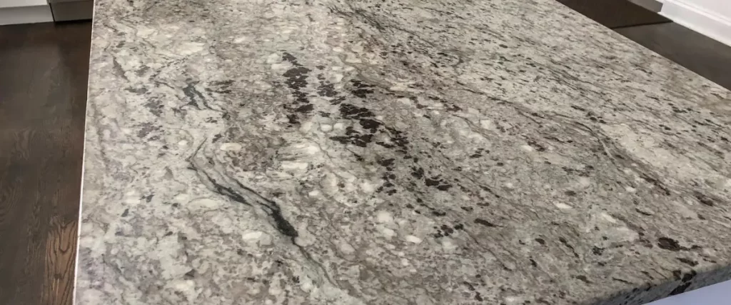 A close-up of a speckled gray and black granite countertop.