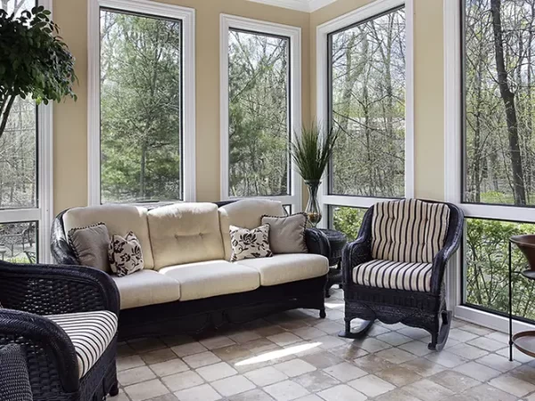 Bright sunroom home addition in berwyn with wicker furniture, large windows, and natural light, perfect for relaxing and enjoying outdoor views in a cozy setting.